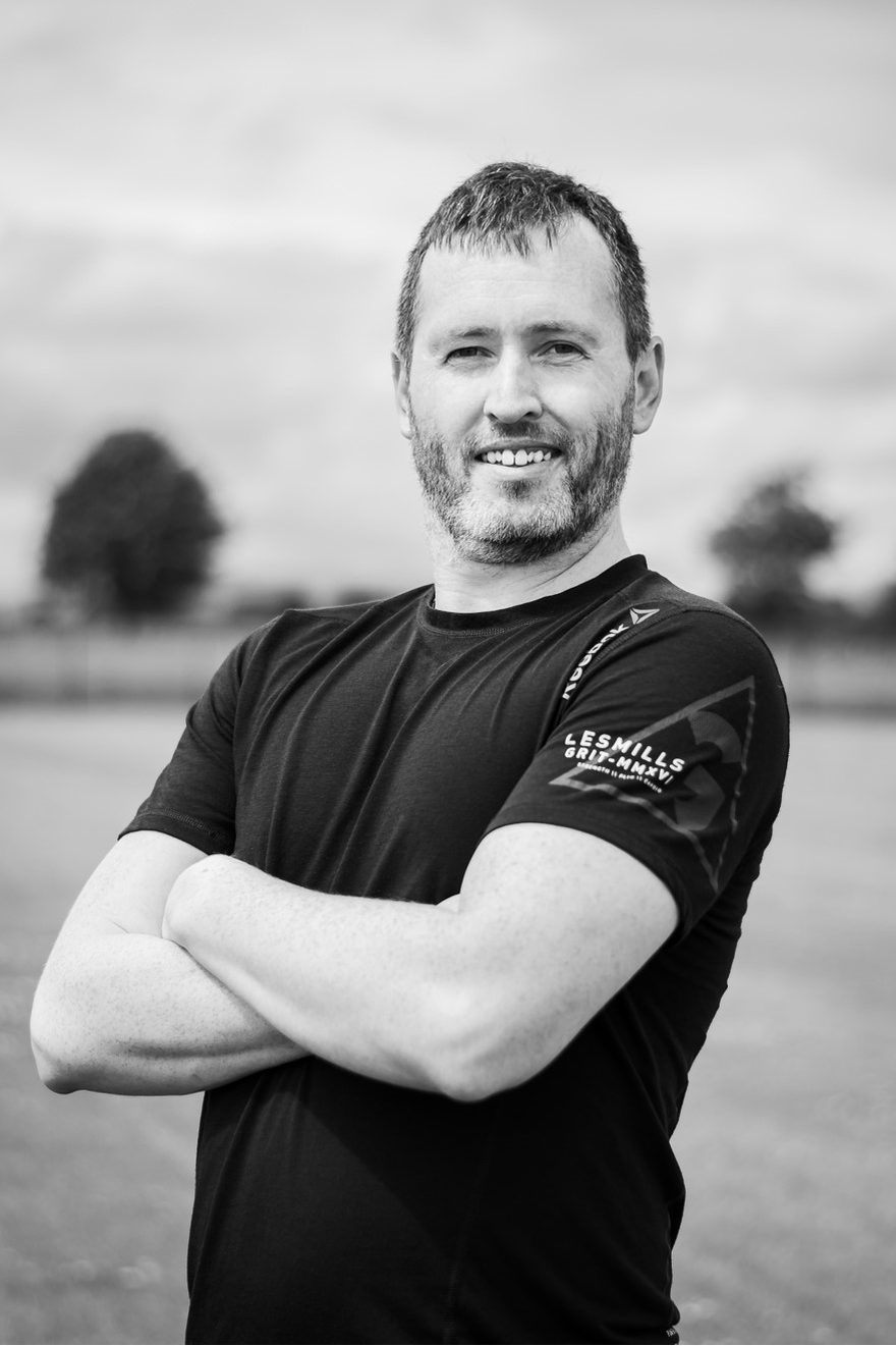 Davie, founder of Dynamic Fit Tech, in a black training top with arms crossed